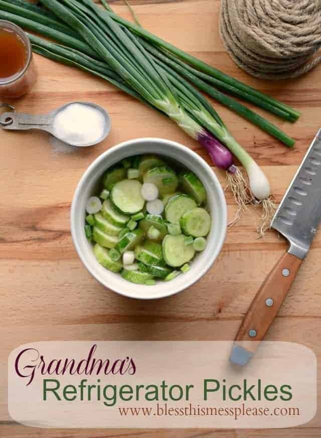 Quick and easy pickled cucumbers with onion a measuring spoon full of sugar and a knife on wooden surface.
